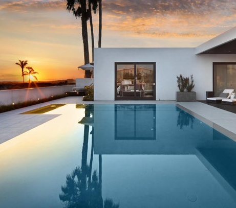 Exterior of luxury home with pool at sunset